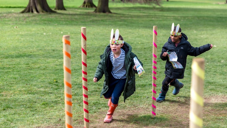 Two children running through the Easter trail wearing bunny ears at Beningbrough Hall, North Yorkshire